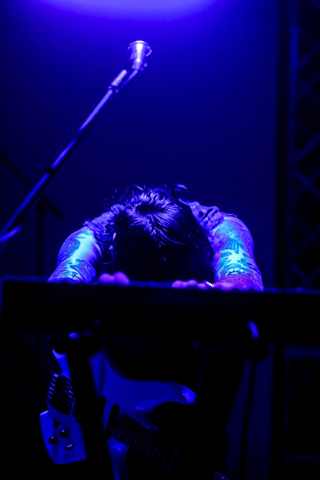 Performer over keyboard in blue light