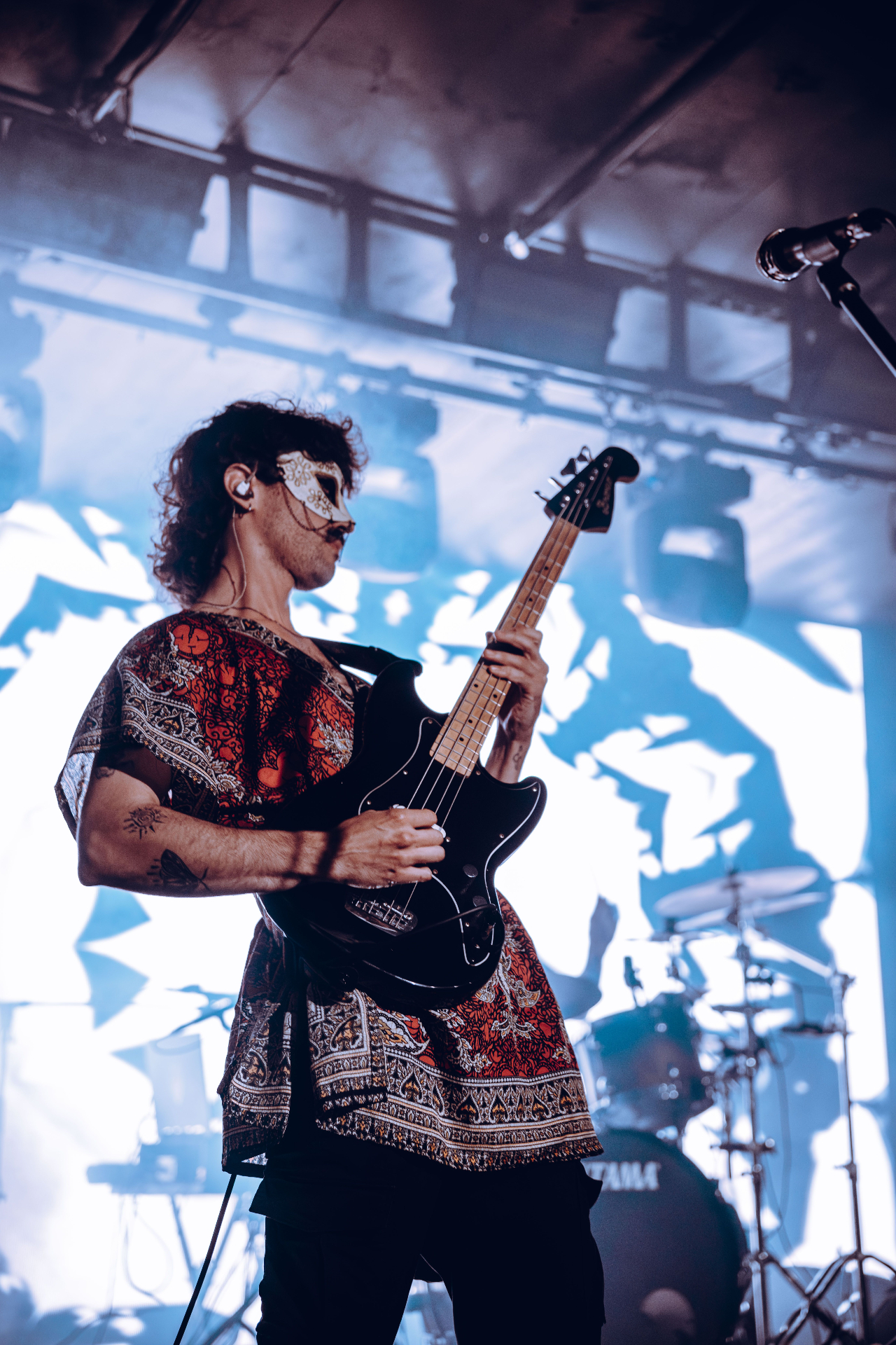 Bassist with mask under blue lights