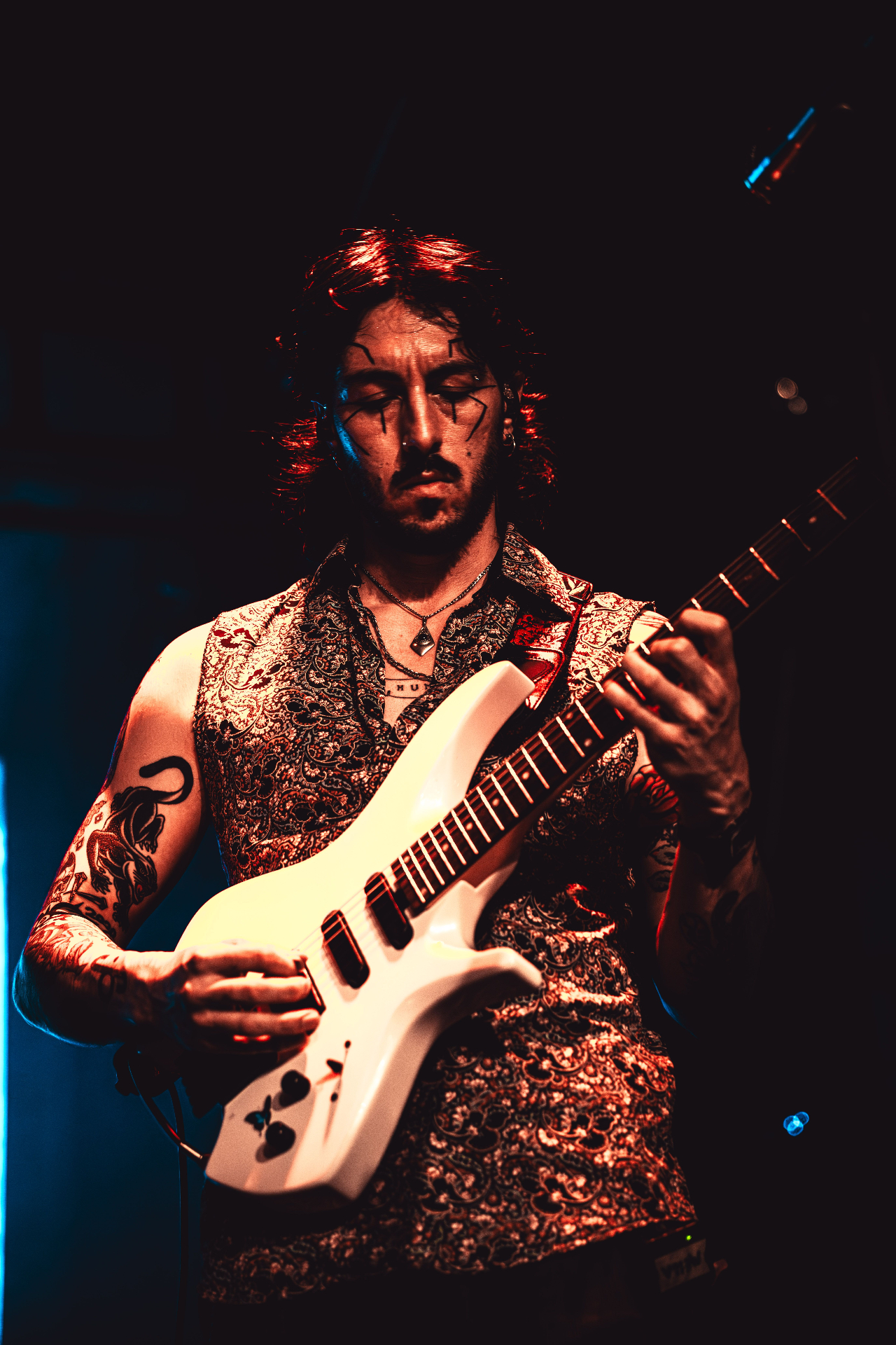 Guitarist with white guitar in red light